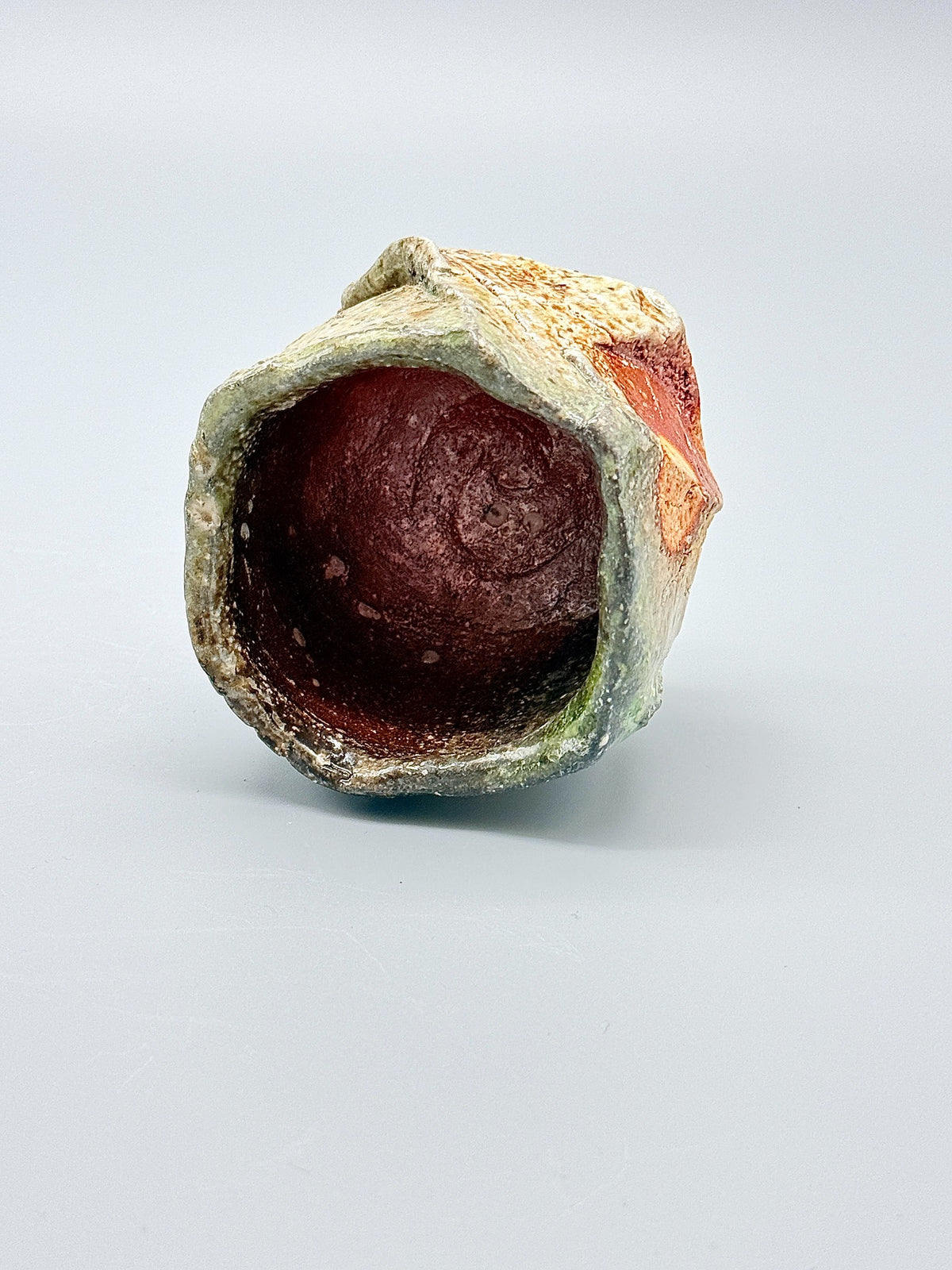 Top view of Atarashi Manabu Iga kurinuki cup, showing the uneven rim and warm brown interior.