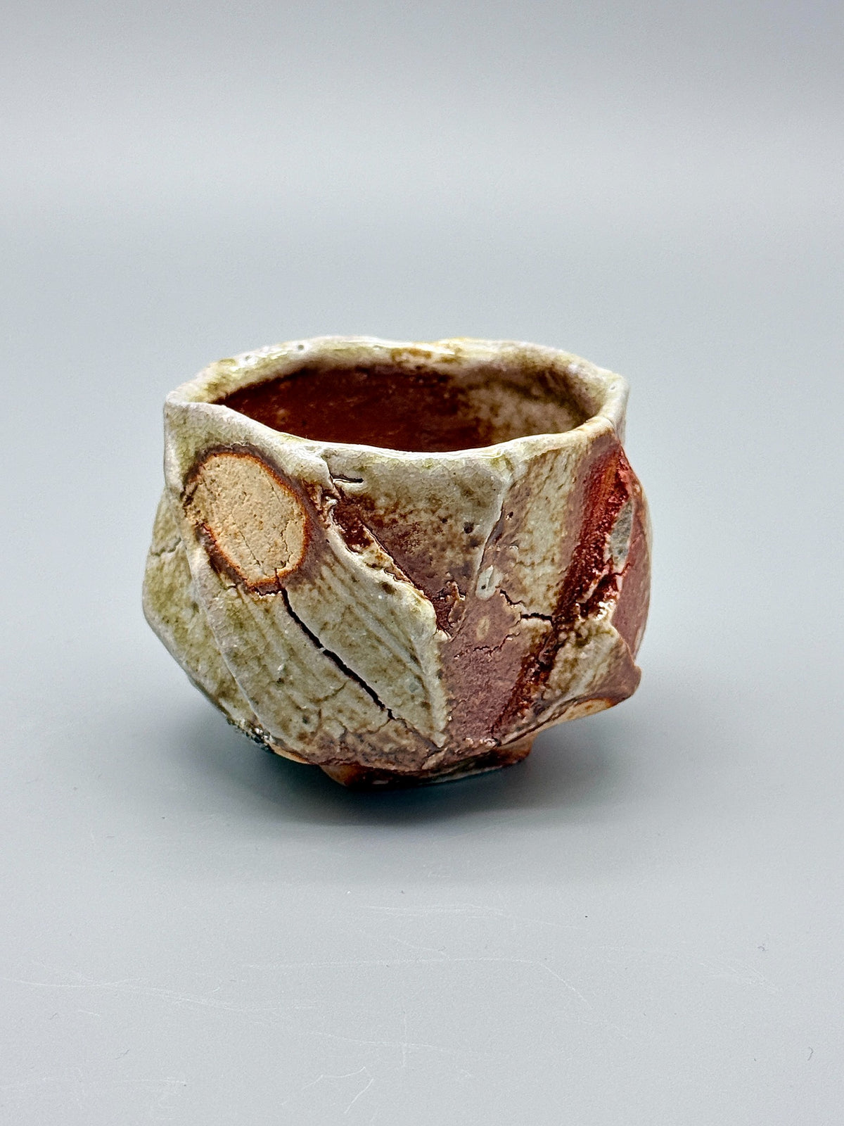 Atarashi Manabu Iga kurinuki cup with pale yellow-green glaze and reddish-brown carved planes.