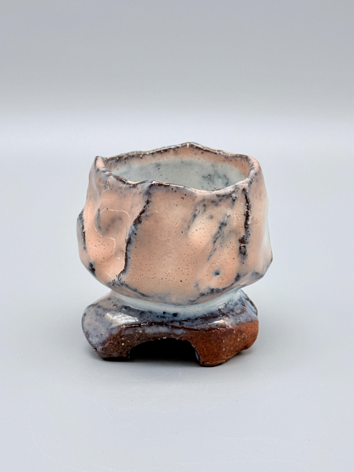 Kaneta Masanao footed cup, front view with rose-blush glaze and a notched foot.