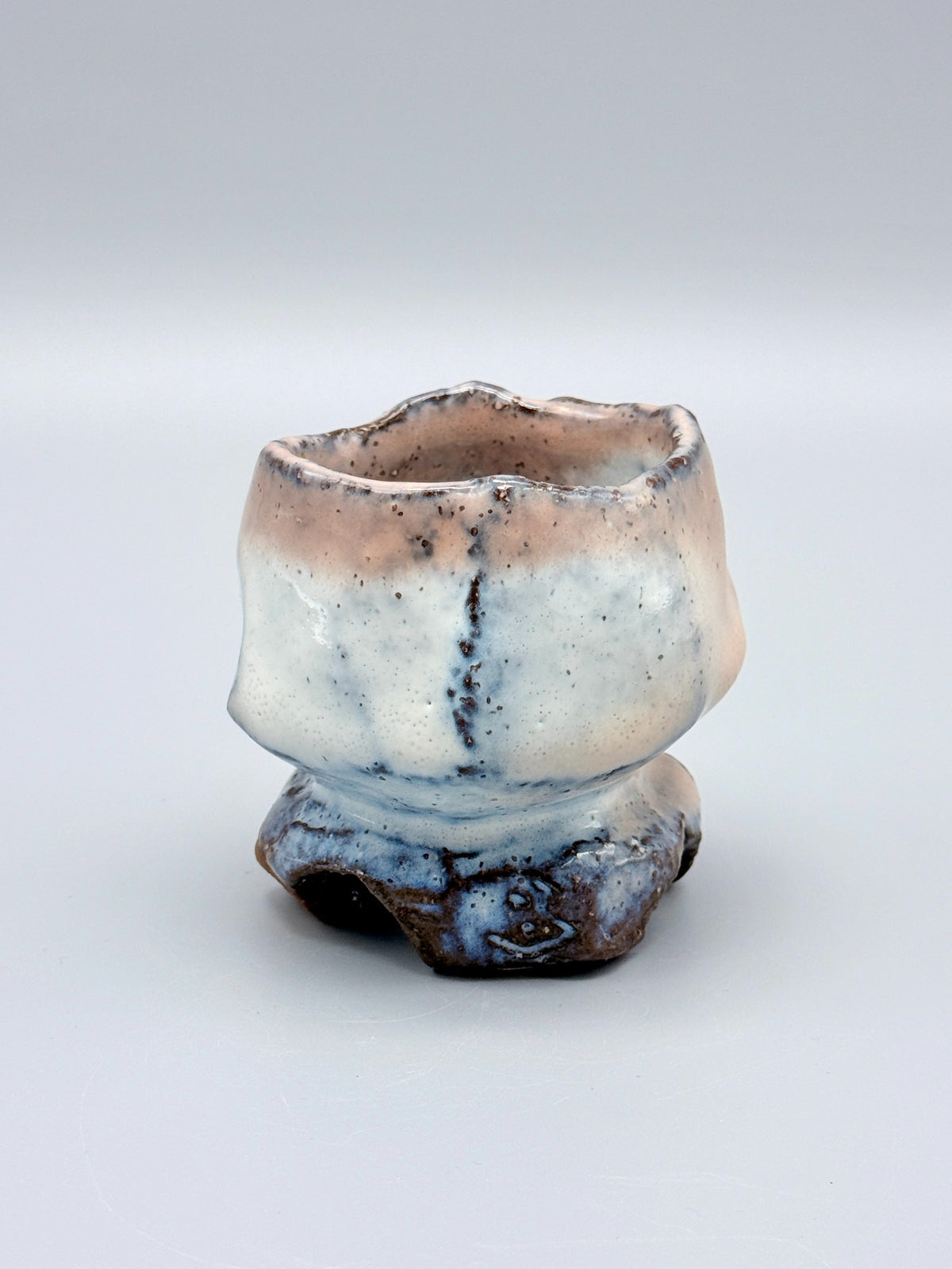 Reverse of Kaneta Masanao footed cup, showing milky white glaze and dark vertical lines.